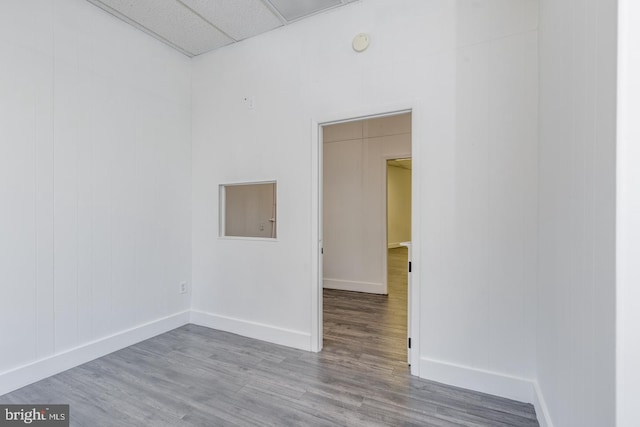 unfurnished room featuring hardwood / wood-style flooring and a paneled ceiling