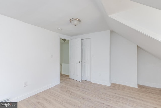 additional living space with lofted ceiling and light wood-type flooring