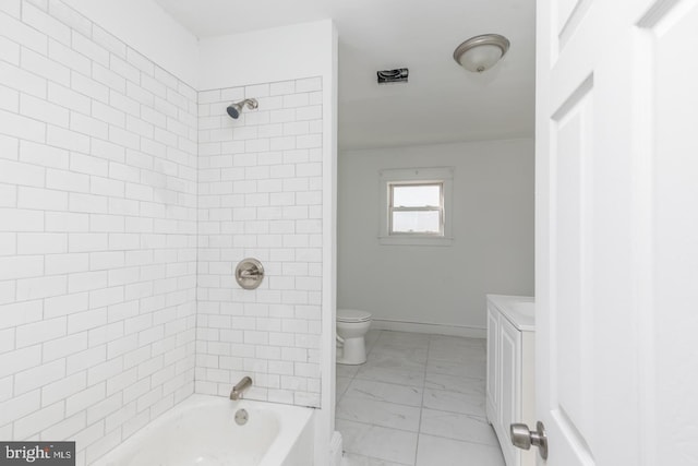 full bathroom featuring vanity, tiled shower / bath combo, and toilet