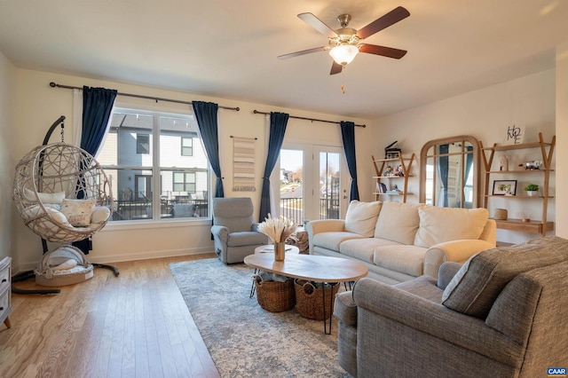 living room with ceiling fan, light wood-type flooring, and a wealth of natural light