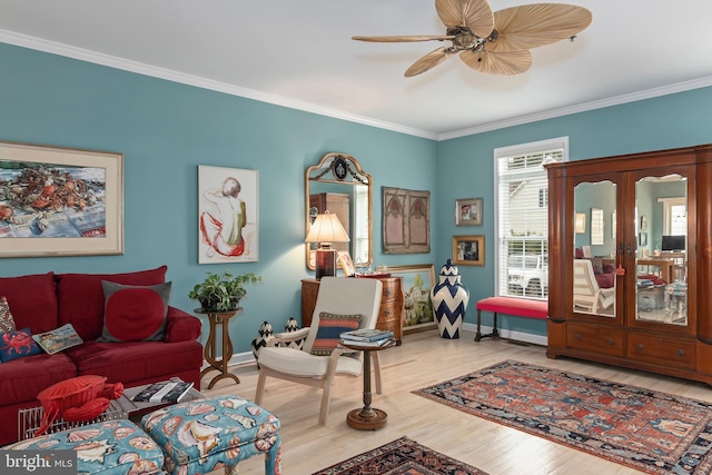 sitting room featuring hardwood / wood-style floors, ceiling fan, and ornamental molding