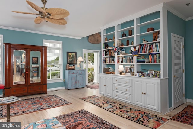 interior space with ceiling fan, light wood-type flooring, and ornamental molding