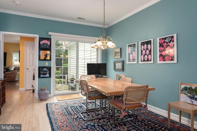 dining room featuring an inviting chandelier, ornamental molding, and light hardwood / wood-style flooring