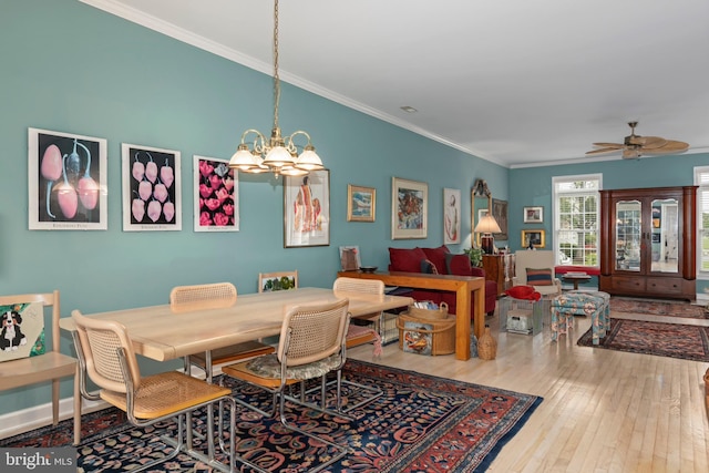 dining room featuring hardwood / wood-style floors, ceiling fan with notable chandelier, and crown molding