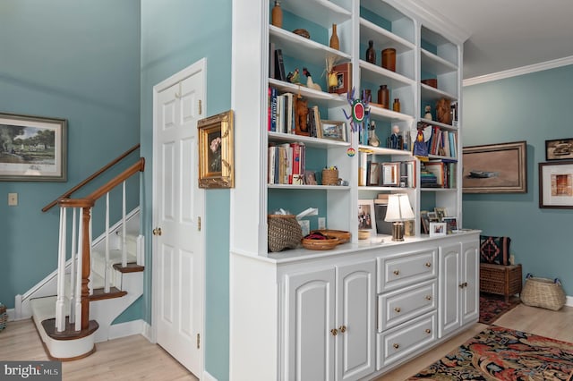 hall with crown molding and light hardwood / wood-style floors