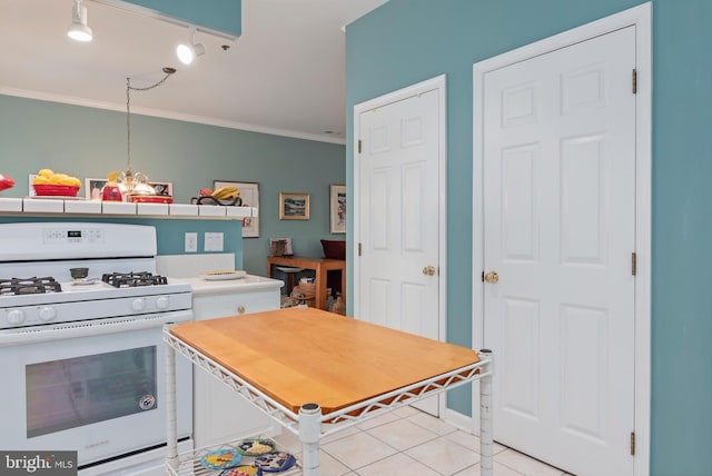 kitchen with white gas stove, crown molding, pendant lighting, a chandelier, and light tile patterned flooring