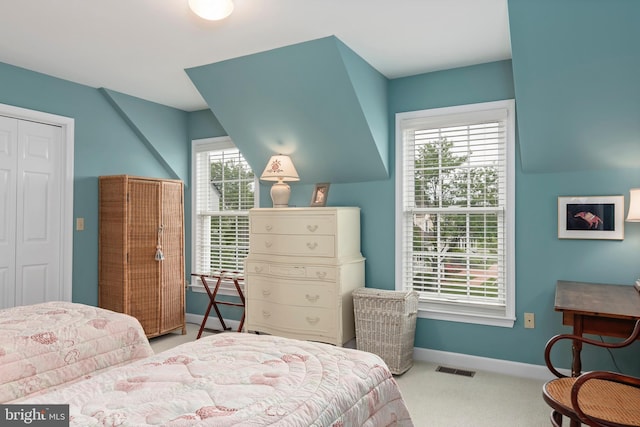 bedroom with light carpet and a closet