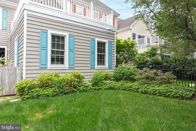 view of property exterior with a lawn and a balcony