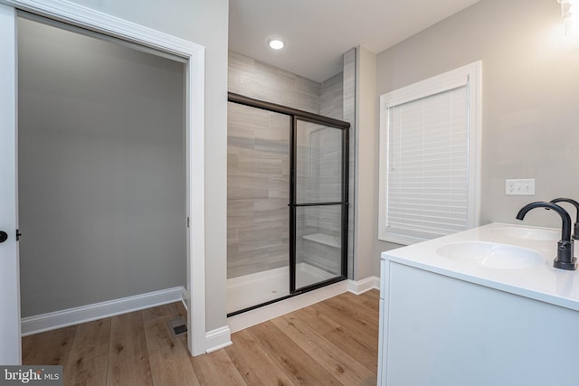 bathroom with vanity, hardwood / wood-style flooring, and walk in shower