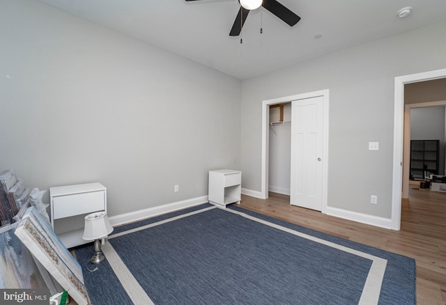 bedroom featuring ceiling fan, dark hardwood / wood-style floors, and a closet