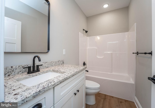 full bathroom featuring vanity, toilet, wood-type flooring, and bathing tub / shower combination