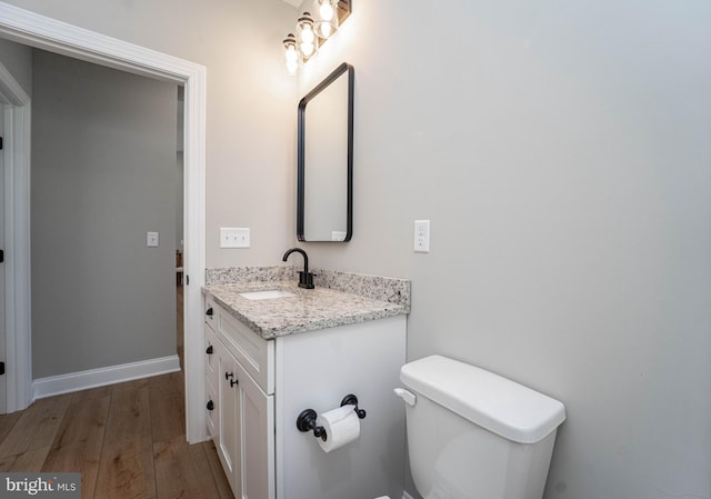 bathroom featuring hardwood / wood-style flooring, vanity, and toilet