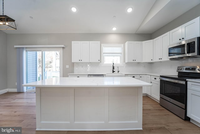 kitchen featuring white cabinets, a healthy amount of sunlight, sink, and appliances with stainless steel finishes