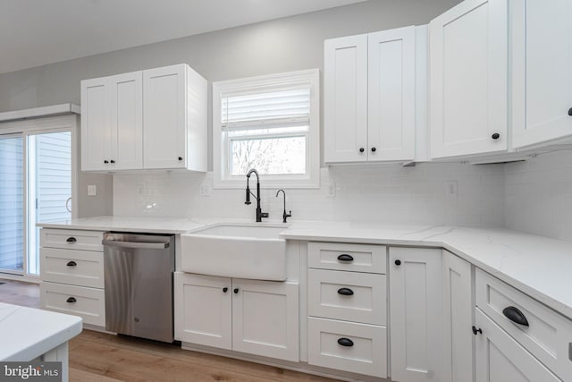 kitchen with backsplash, sink, stainless steel dishwasher, light hardwood / wood-style floors, and white cabinetry