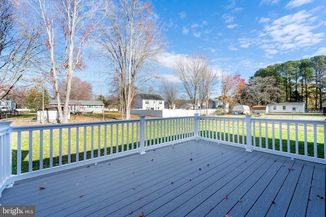 wooden deck featuring a lawn