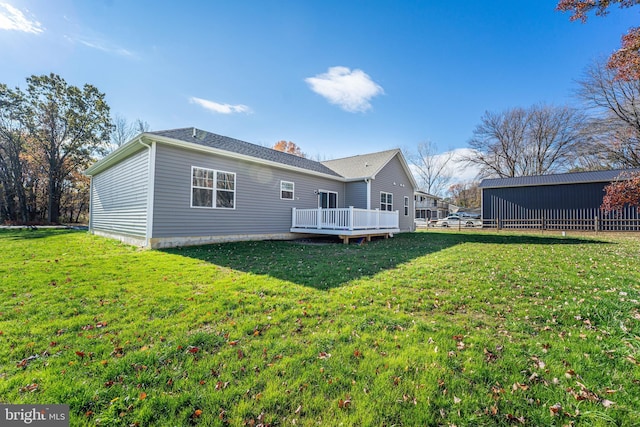 back of house with a deck and a yard