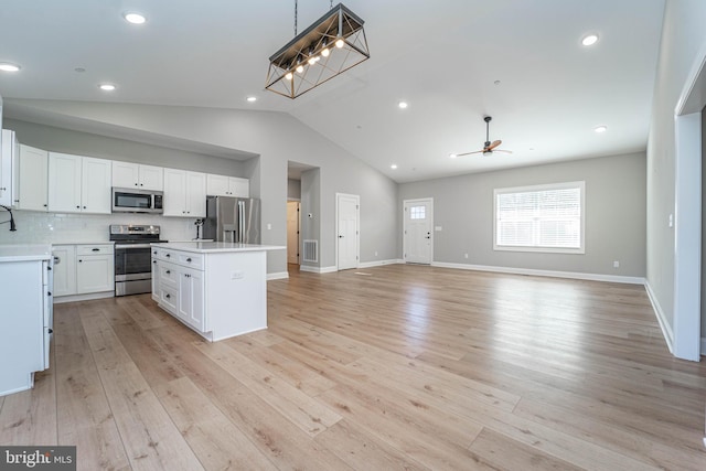 kitchen featuring a center island, white cabinetry, appliances with stainless steel finishes, and light hardwood / wood-style flooring