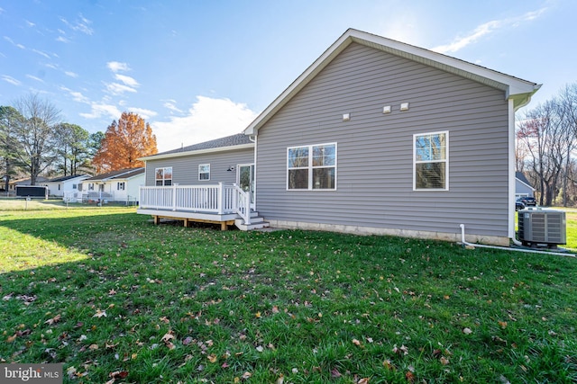 back of property with a yard, a deck, and central AC unit