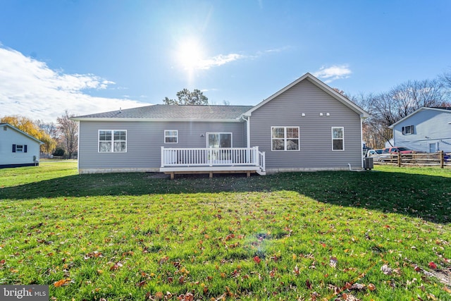 rear view of house with a yard and a deck