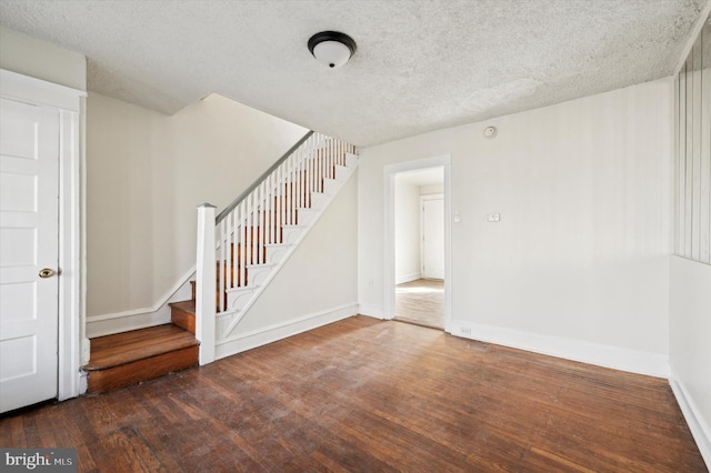 interior space featuring dark wood-type flooring and a textured ceiling