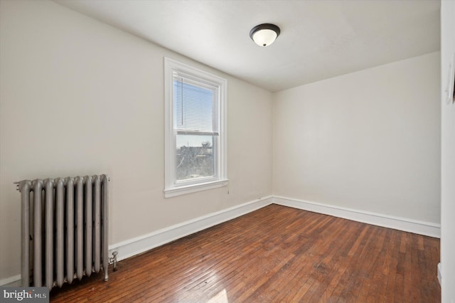 unfurnished room with dark hardwood / wood-style floors and radiator