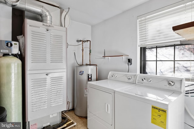 clothes washing area featuring washing machine and clothes dryer and electric water heater