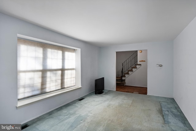 unfurnished living room featuring carpet and a healthy amount of sunlight