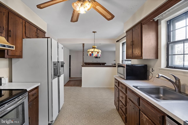 kitchen with stainless steel appliances, extractor fan, ceiling fan, sink, and pendant lighting