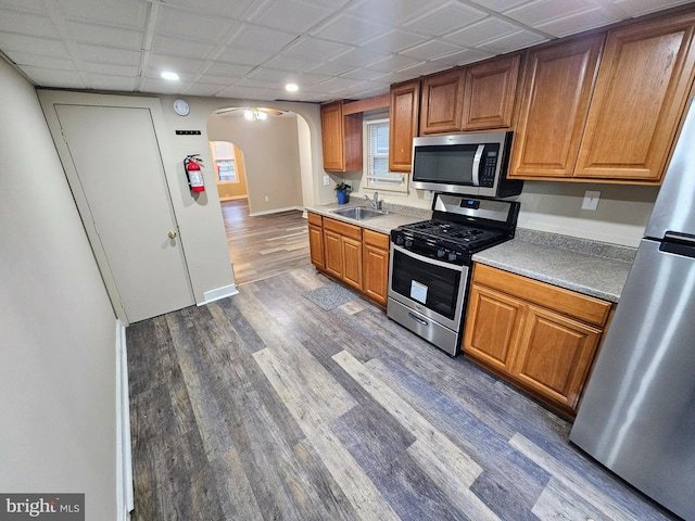 kitchen featuring a drop ceiling, sink, stainless steel appliances, and dark wood-type flooring