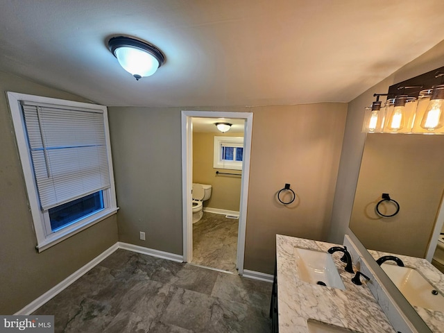 bathroom with vanity, toilet, and lofted ceiling