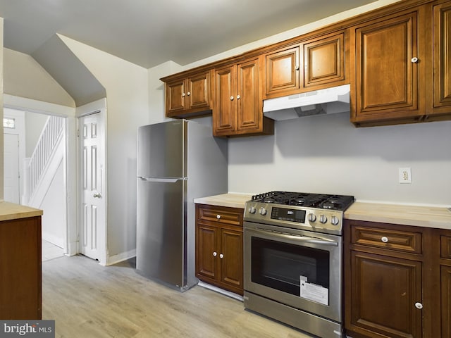 kitchen featuring light hardwood / wood-style floors, lofted ceiling, and stainless steel appliances