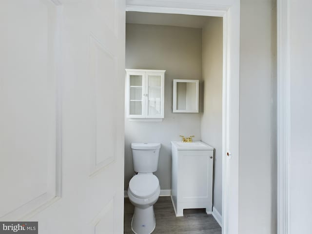 bathroom with toilet, wood-type flooring, and sink