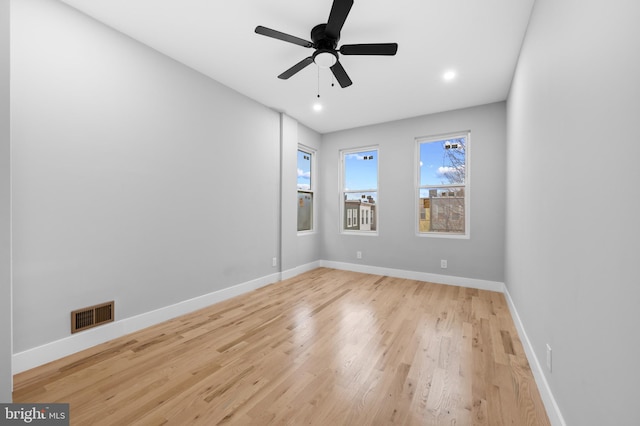 spare room with ceiling fan and light wood-type flooring