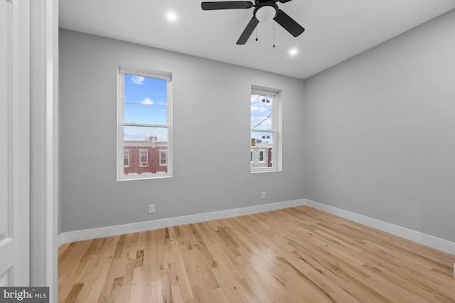 spare room featuring light hardwood / wood-style flooring, ceiling fan, and a healthy amount of sunlight