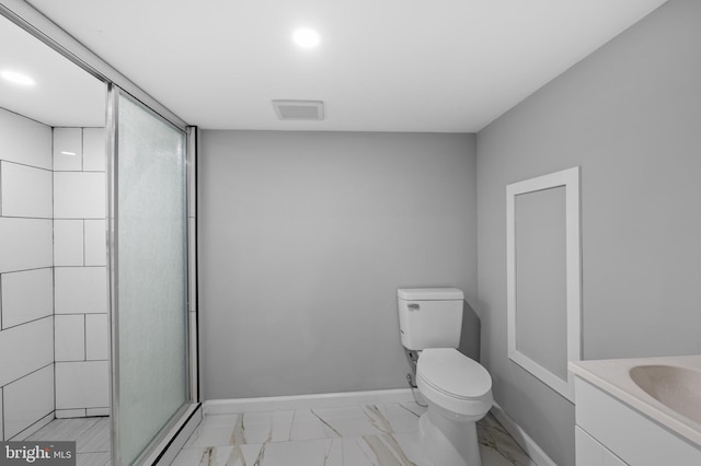 bathroom with a shower with door, vanity, and toilet