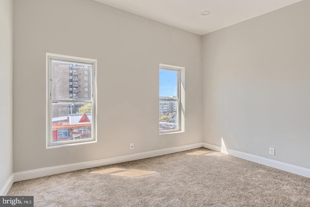 unfurnished room with a wealth of natural light and carpet