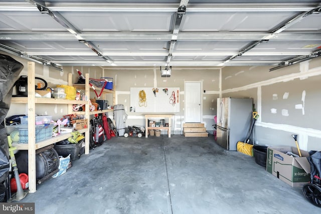 garage featuring stainless steel fridge and a garage door opener