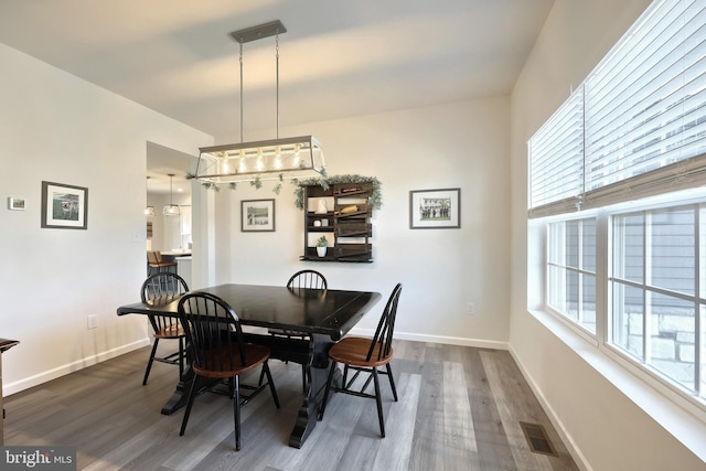 dining area with plenty of natural light and dark wood-type flooring