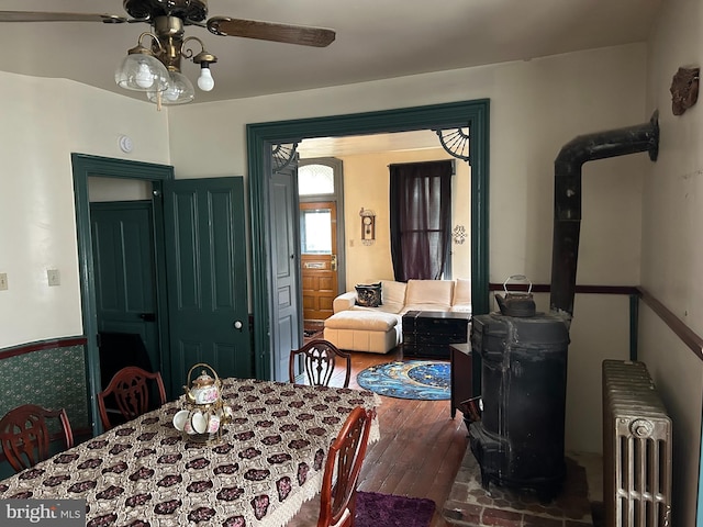 dining space featuring dark hardwood / wood-style flooring, radiator, and ceiling fan