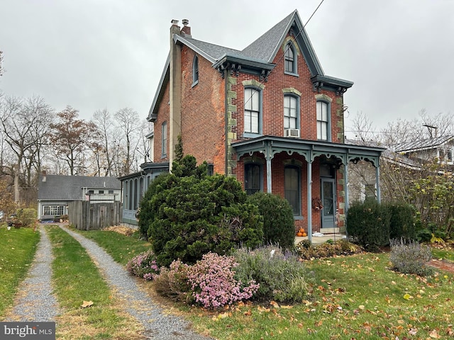 view of front of home featuring cooling unit and a front yard