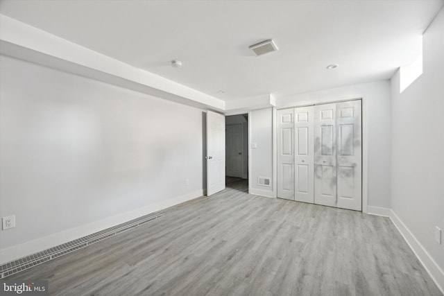 unfurnished bedroom featuring light hardwood / wood-style flooring and a closet