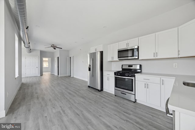 kitchen featuring white cabinetry, light hardwood / wood-style flooring, ceiling fan, and appliances with stainless steel finishes