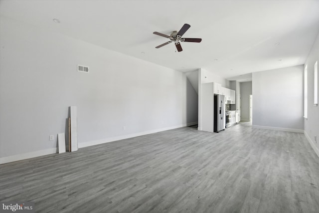 unfurnished living room featuring light hardwood / wood-style flooring and ceiling fan