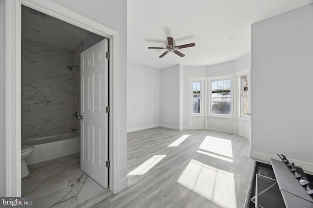 unfurnished living room featuring ceiling fan and light wood-type flooring