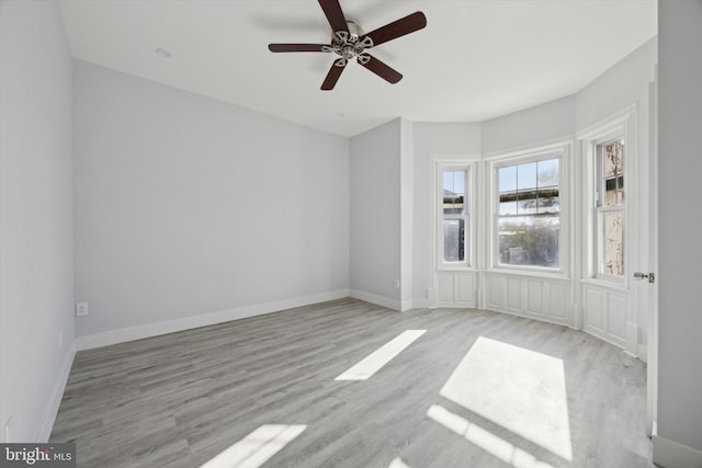 empty room with ceiling fan and light hardwood / wood-style floors