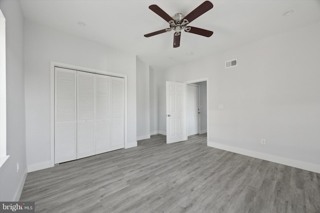 unfurnished bedroom with a closet, light hardwood / wood-style flooring, and ceiling fan