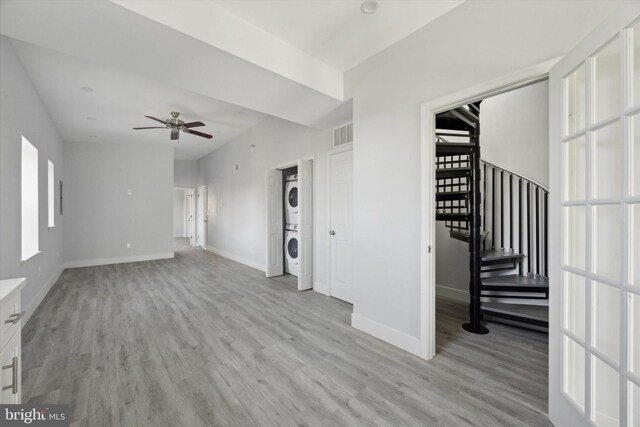 1939 W Diamond St, Philadelphia, PA 19121 - unfurnished living room featuring stacked washer / drying machine, light wood finished floors, ceiling fan, and stairway