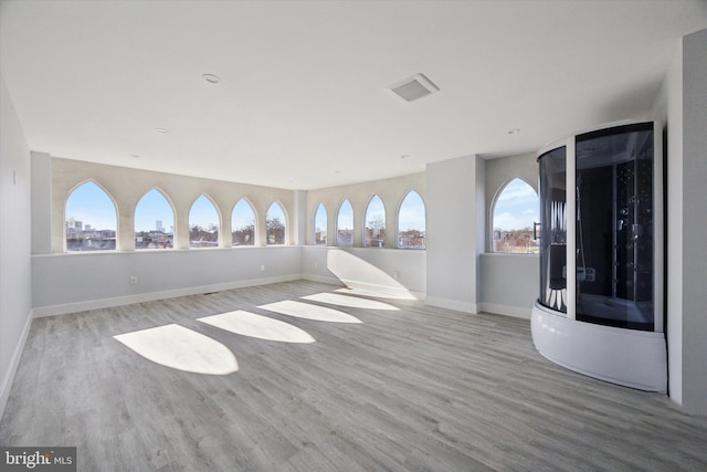 1939 W Diamond St, Philadelphia, PA 19121 - spare room featuring wood finished floors, healthy amount of natural light, a view of city, and arched walkways