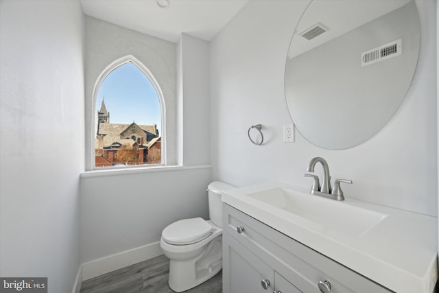 bathroom featuring wood-type flooring, vanity, and toilet