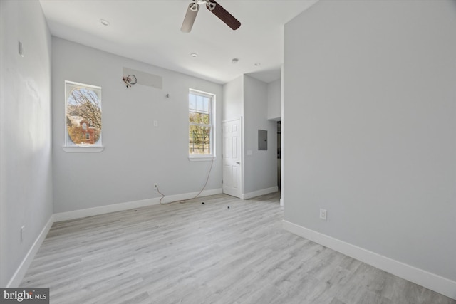 unfurnished room with ceiling fan, light hardwood / wood-style floors, and electric panel